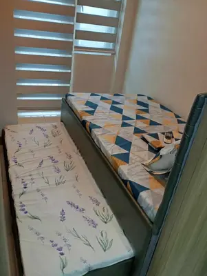 a bed with a quilt on it in a room at Condo next door in Manila