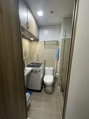 a small bathroom with a toilet and a sink at Condo next door in Manila
