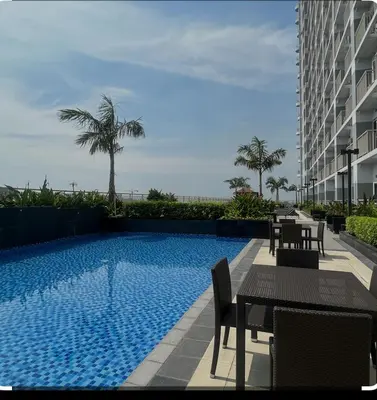 a swimming pool with tables and chairs next to a building at Condo next door in Manila