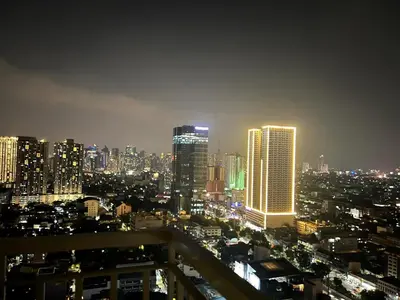 a city skyline at night with tall buildings at Condo next door in Manila