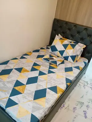 a bed with a quilt and two pillows on it at Condo next door in Manila