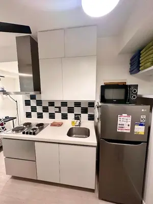 a kitchen with a refrigerator and a sink at Azure 2Br 1Ba with City View Balcony and Free Parking in Manila