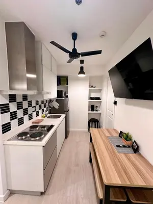 a kitchen with a table and a ceiling fan at Azure 2Br 1Ba with City View Balcony and Free Parking in Manila