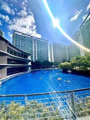 a large swimming pool in a city with tall buildings at Azure 2Br 1Ba with City View Balcony and Free Parking in Manila