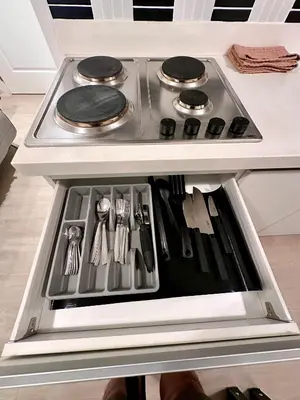 a stove top oven with utensils in a drawer at Azure 2Br 1Ba with City View Balcony and Free Parking in Manila