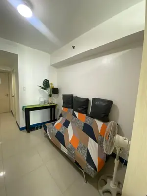 a bedroom with a bed and a fan at Sea Residences MOA Pasay City - Reynil in Manila