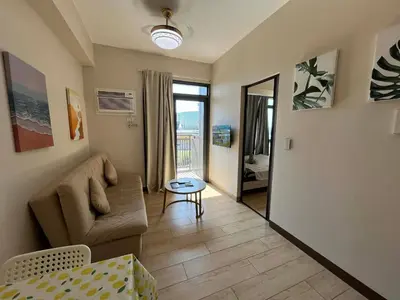 a living room with a couch and a table at Gentry Manor Balcony Sea View WiFi Netflix Near Airport Okada 8B in Manila
