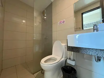 a bathroom with a toilet and a glass shower at Gentry Manor Balcony Sea View WiFi Netflix Near Airport Okada 8B in Manila