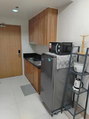 a small kitchen with a refrigerator and a microwave at JL shore Staycation in Manila