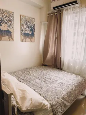 a bedroom with a bed and a window with a curtain at Pasay Condo near MOA, NAIA, CBD and Casinos in Manila