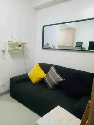 a black couch with a yellow pillow in a room at Pasay Condo near MOA, NAIA, CBD and Casinos in Manila