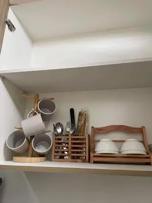 a shelf with bowls and utensils on it at Pasay Condo near MOA, NAIA, CBD and Casinos in Manila