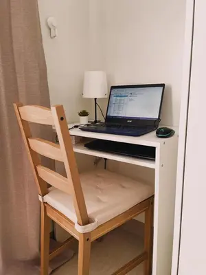 a laptop computer sitting on a desk with a chair at Pasay Condo near MOA, NAIA, CBD and Casinos in Manila