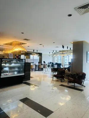 a lobby with chairs and tables in a building at Hotel Apartment Suite near Makati in Manila