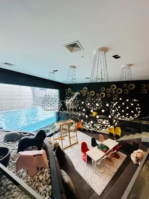 a large room with a swimming pool and a room with furniture at Hotel Apartment Suite near Makati in Manila
