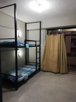 a room with three bunk beds and a curtain at Manila Real Residences 8A in Manila