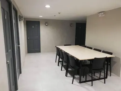 a conference room with a table and black chairs at Manila Real Residences 8A in Manila