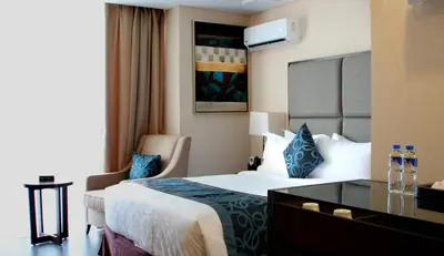 a hotel room with a large bed and a desk at Golden Phoenix Hotel - Manila in Manila