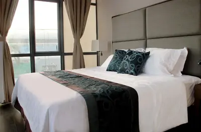 a bedroom with a large bed with a large window at Golden Phoenix Hotel - Manila in Manila