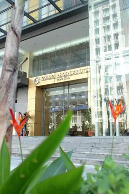 a building with red flowers in front of it at Golden Phoenix Hotel - Manila in Manila