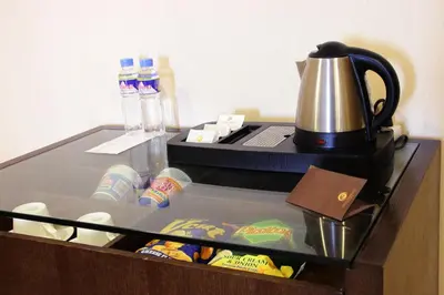 a refrigerator with a tea kettle on top of it at Golden Phoenix Hotel - Manila in Manila