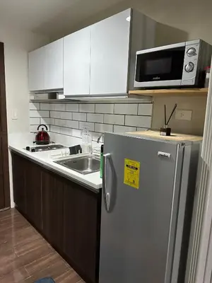 a kitchen with a stainless steel refrigerator and a microwave at Affordable Ayala Makati 1BR Condo in Manila