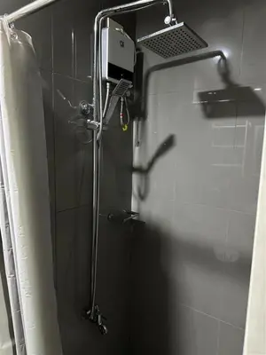 a shower in a bathroom with a glass door at Affordable Ayala Makati 1BR Condo in Manila