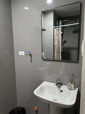 a white bathroom with a sink and a mirror at King-size Bed Makati Condo in Manila