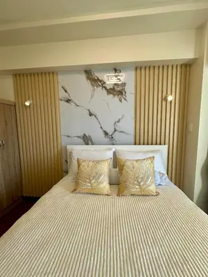 a bedroom with a large bed with two pillows at Condo in Taguig in Manila