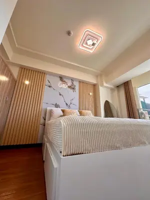 a bedroom with a large white bed in a room at Condo in Taguig in Manila