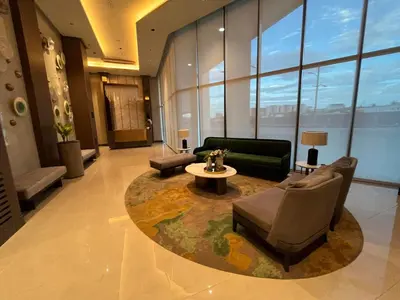 a lobby with a living room with a couch and a table at Gentry Manor Family Suite Facing Okada Fountain WiFi Netflix Near Airport 8A in Manila
