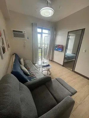 a living room with a couch and a mirror at Gentry Manor Family Suite Facing Okada Fountain WiFi Netflix Near Airport 8A in Manila