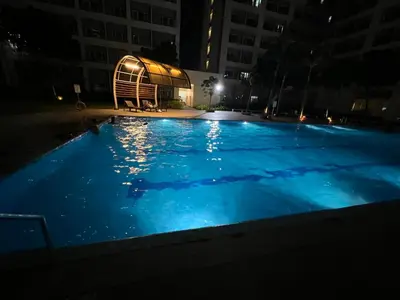 an empty swimming pool at night with a building at Kaths Place in Manila