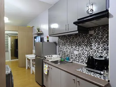 a kitchen with a refrigerator and a counter top at Kaths Place in Manila