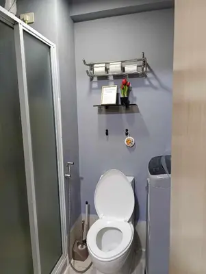 a bathroom with a white toilet and a shower at Kaths Place in Manila