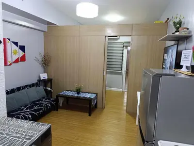 a small living room with a couch and a refrigerator at Kaths Place in Manila