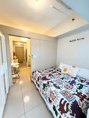 a bedroom with a bed with a colorful blanket at Fun Pop-Art Inspired Makati Studio in Manila