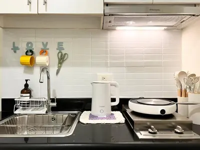 a kitchen with a sink and a counter top with aounter at Fun Pop-Art Inspired Makati Studio in Manila