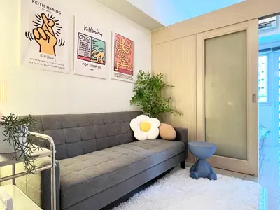a living room with a gray couch and posters on the wall at Fun Pop-Art Inspired Makati Studio in Manila