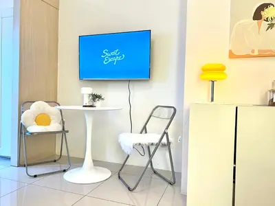a room with a tv on a wall with a table and chairs at Fun Pop-Art Inspired Makati Studio in Manila