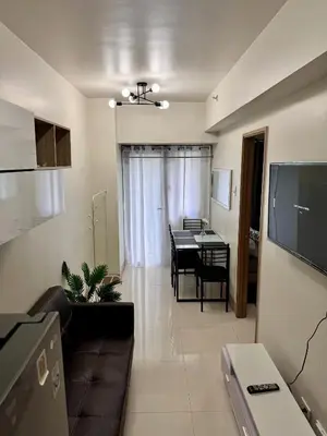 a living room with a couch and a dining room at Hearth of Ember at Shore 3 in Manila