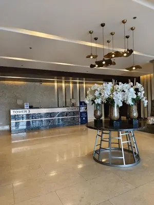 a lobby with a table with vases of flowers on it at Hearth of Ember at Shore 3 in Manila