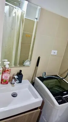 a bathroom with a sink and a mirror and a toilet at Hearth of Ember at Shore 3 in Manila