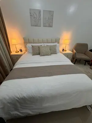 a bedroom with a large white bed with two lamps at Green 2 - Gems Suite in Dasmariñas