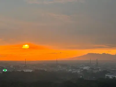 a sunset over a city with mountains in the background at Green 2 - Gems Suite in Dasmariñas
