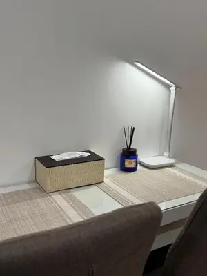 a desk with a bed and a lamp and a box at Green 2 - Gems Suite in Dasmariñas