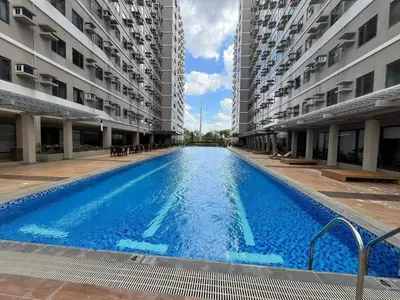 a large swimming pool between two tall buildings at Green 2 - Gems Suite in Dasmariñas