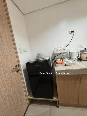 a kitchen with a black refrigerator next to a counter at Green 2 SMDC - STUDIO TYPE Condo - Gems Suite Staycation in Dasmariñas