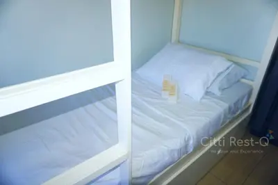 a small white bed in a room with a mirror at Studio City Alabang Pool Access Free for 2 Wifi & Netflix SC1 in Manila