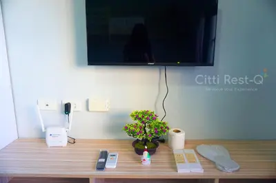 a wooden table with a plant and a television on a wall at Studio City Alabang Pool Access Free for 2 Wifi & Netflix SC1 in Manila